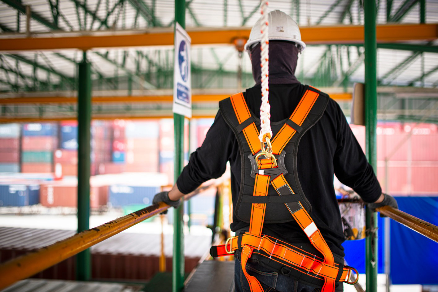 Construction worker wearing safety harness and safety line working on construction.